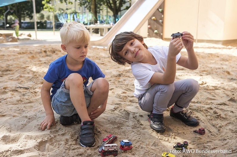 zwei Jungen spielen im Sand