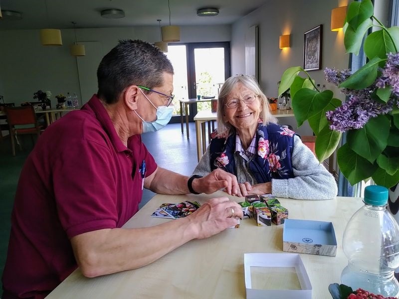 Zwei ältere Menschen plaudern fröhlich am Tisch