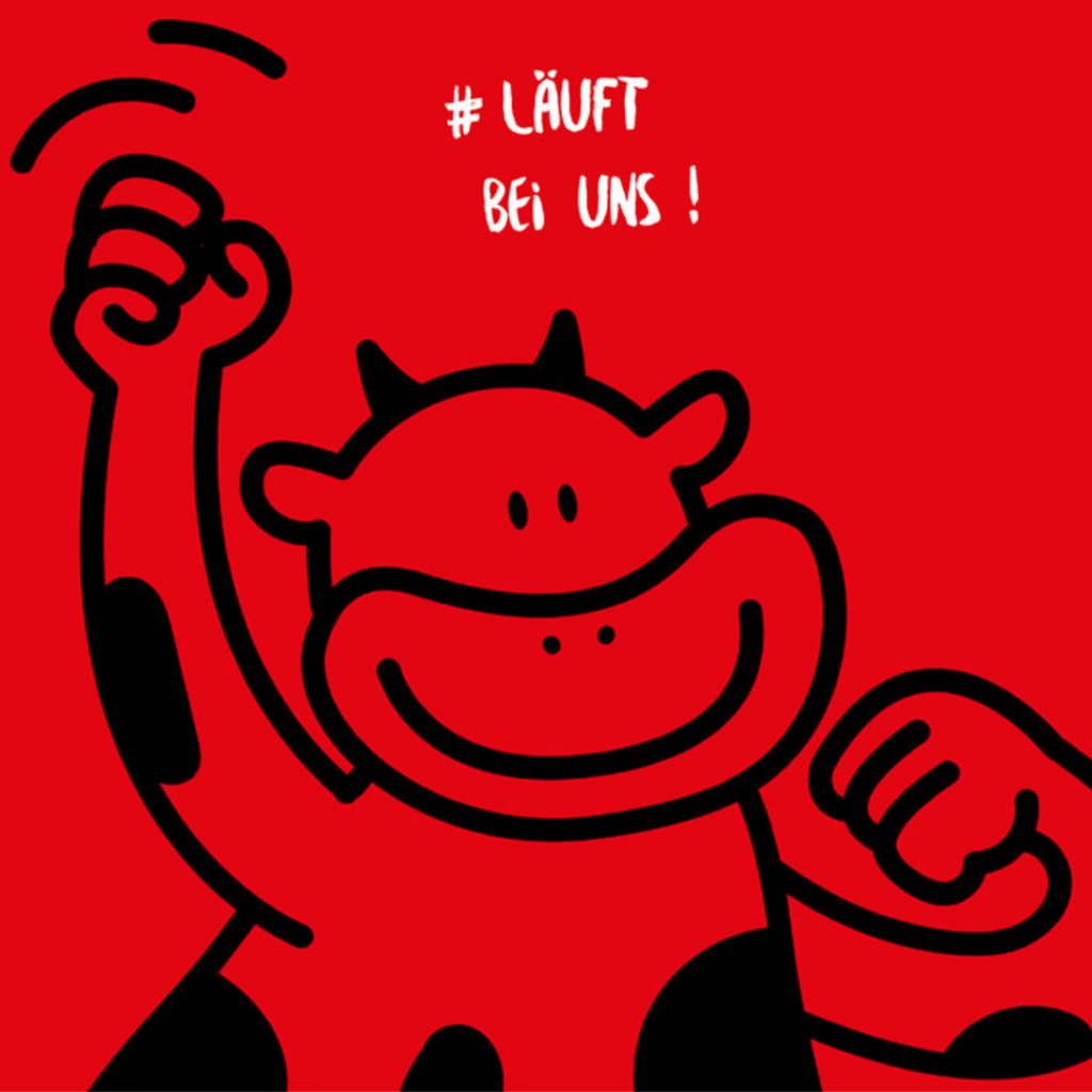 Die Kuh Bunti vor rotem Hintergrund und dem Hashtag #LäuftBeiUns
