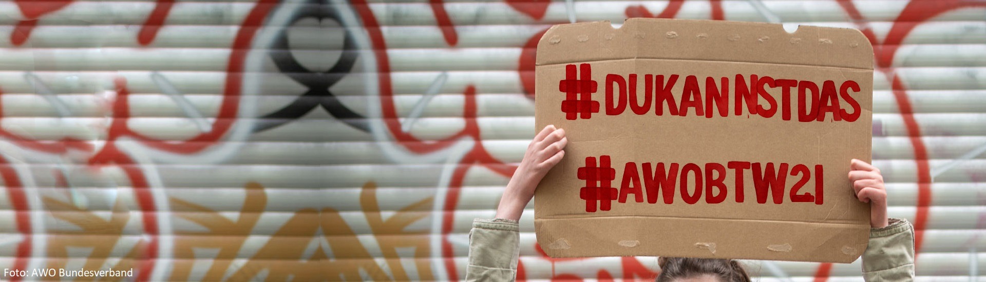 Jemand hält ein Pappschild mit den Hashtags #DuKannstDas und #AWOBTW21 hoch