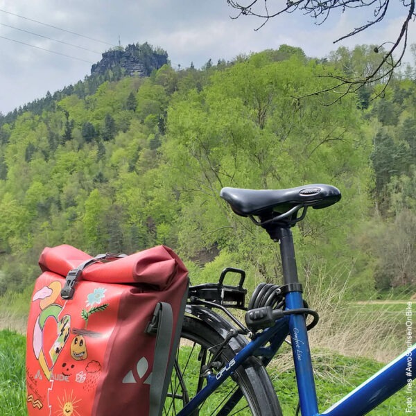 Fahrrad mit Satteltasche, im Hintergrund ein Felsen der Sächsischen Schweiz
