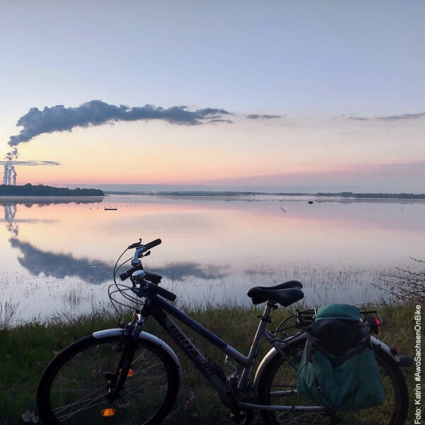 Sonnenuntergang am See, im Vordergrund ein Fahrrad