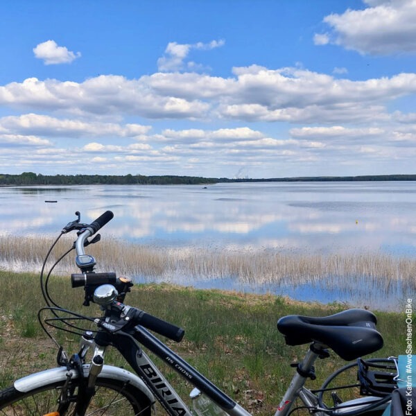 Wolken ziehen über dem See, im Vordergrund ein Fahrrad