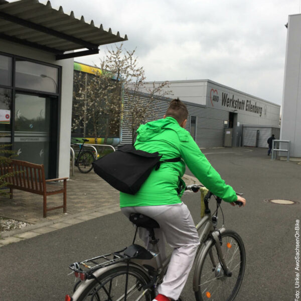 Ulrike mit dem Rad auf dem Weg zum Eingang der Werkstatt Eilenburg