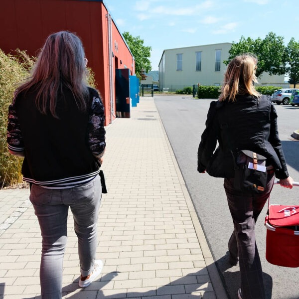 Kathleen fischer und Ulrike Novy laufen an der Werkstatt vorbei