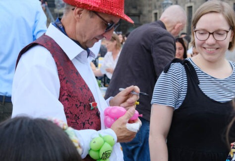 Ein Mann bemalt einen Luftballon