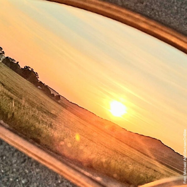 Blick in den Seitenspiegel des Autos mit Sonnenuntergang
