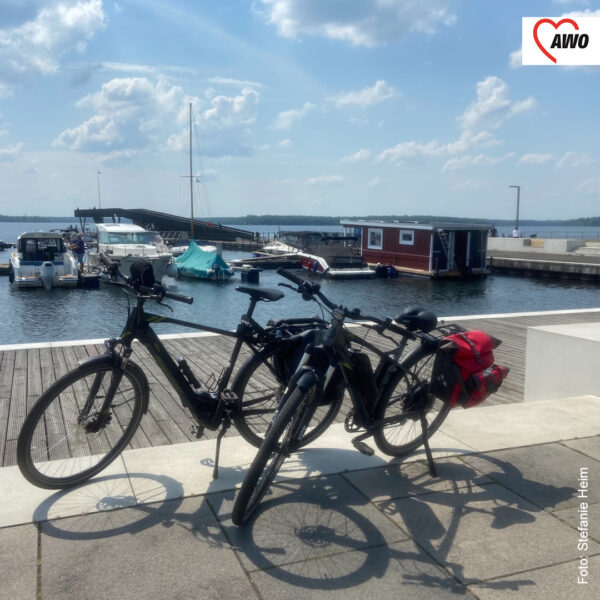 zwei Fahrräder stehen vor einem kleinen Hafen am See