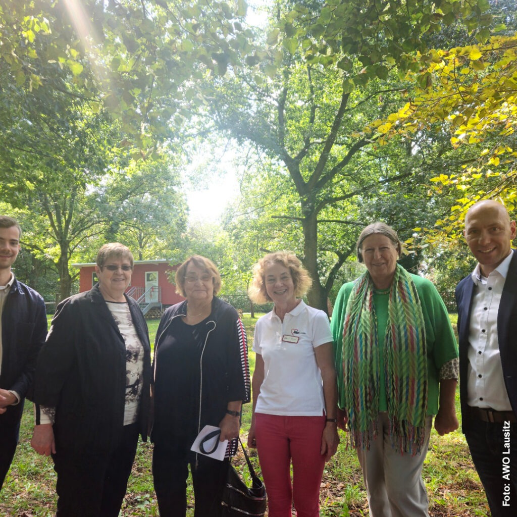 Frau Sonnenholzer mit ihren Gastgebern der AWO Lausitz auf einer sonnigen Lichtung