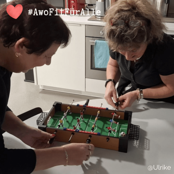 Zwei Frauen haben spaß beim Tischkicker spielen