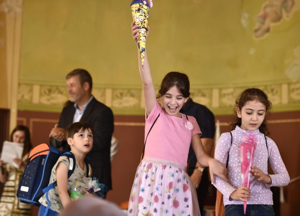 Ein Mädchen hält voller Freude eine Zuckertüte in der Hand