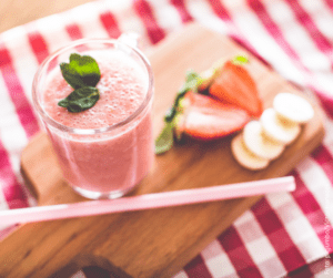 ein rosa Smoothie garniert mit Kräutern 