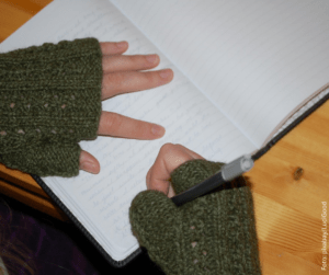 Hände die auf einem Tagebuch liegen und schreiben 